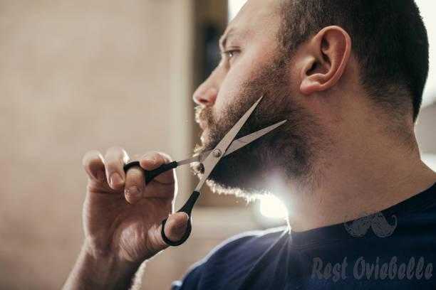 Man cutting beard Do one side first and then the other trim a beard with scissor