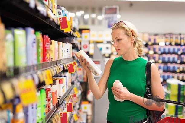 Woman shopping personal hygiene products at supermarket. shower gel vs body wash