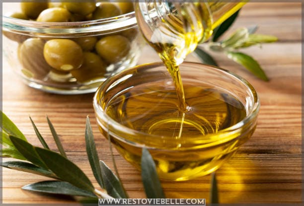 Olive oil in a glass bowl set against a wooden background